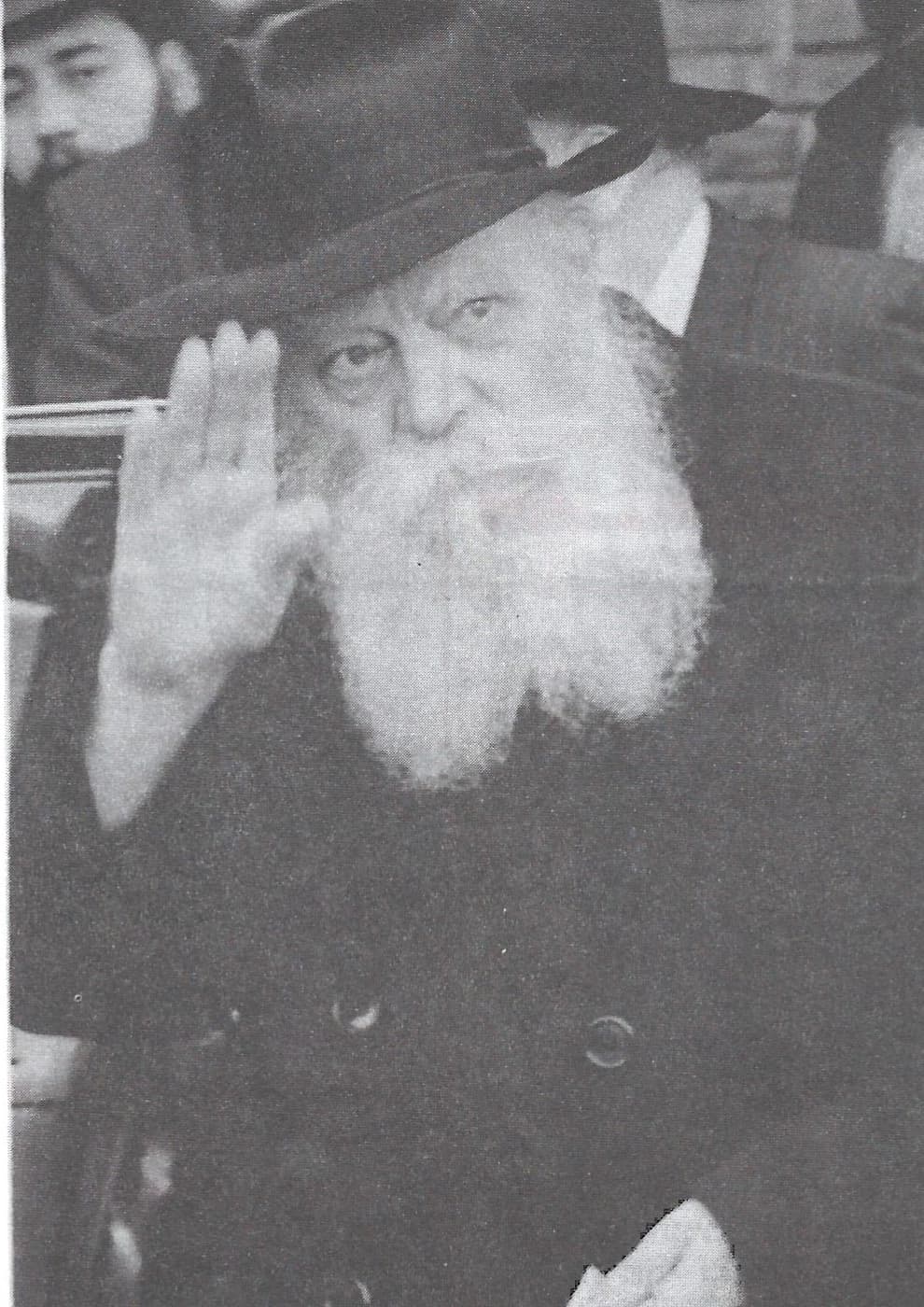 צילום היסטורי בשחור־לבן של הרבי מליובאוויטש מרים את ידו לברכה